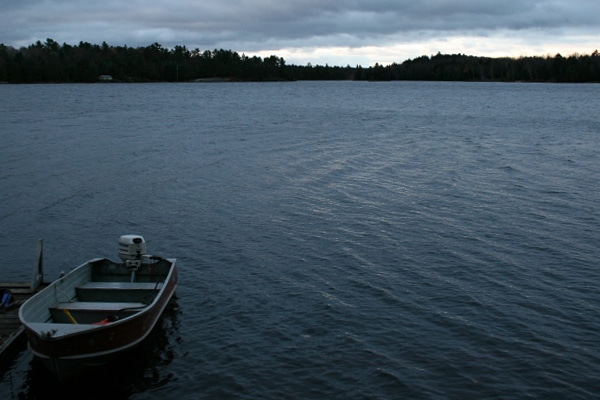 A small boat docked on the water, who needs boating license concept.