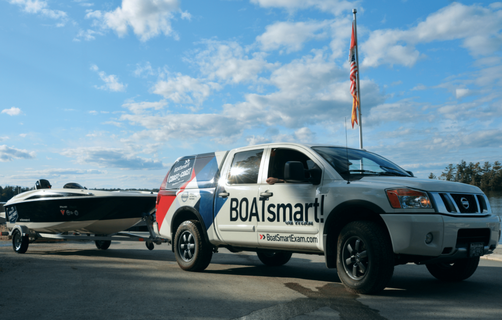 A boat on a trailer behind a truck.