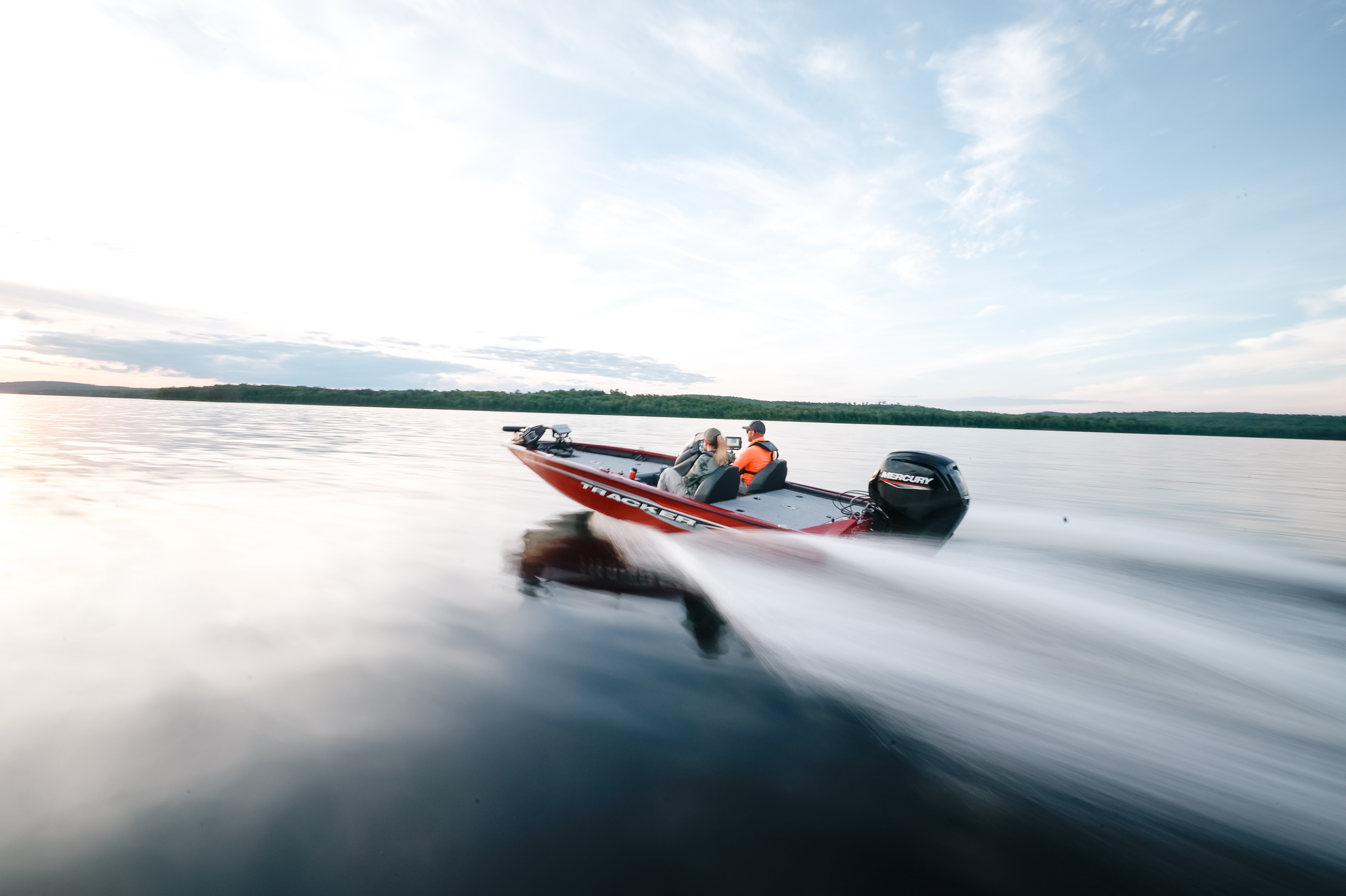 Two people on a boat moving quickly on the water, follow New Jersey boating laws concept.