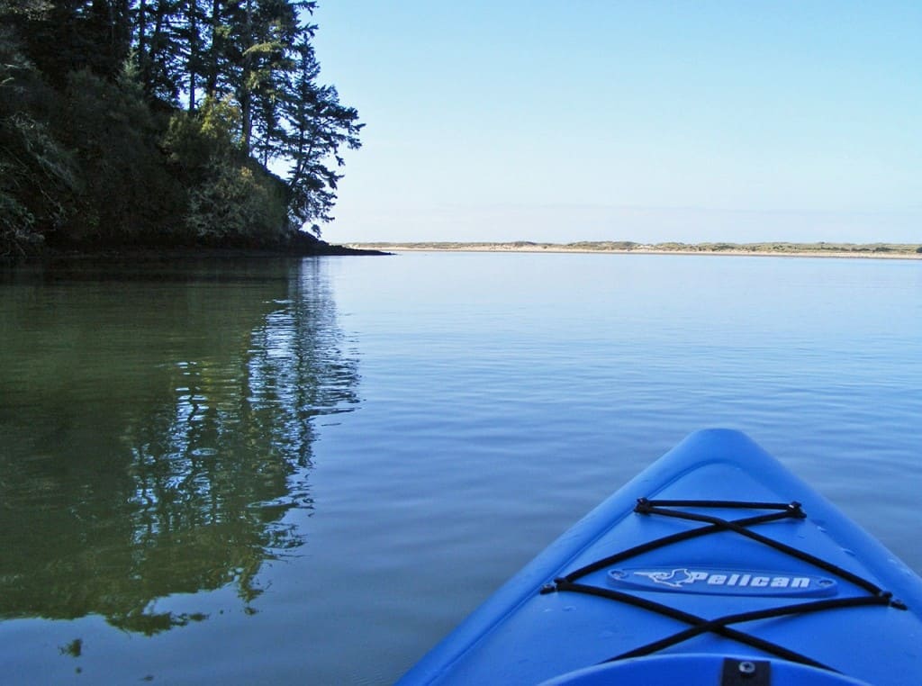 Looking at a calm lake beyond the end of a canoe.