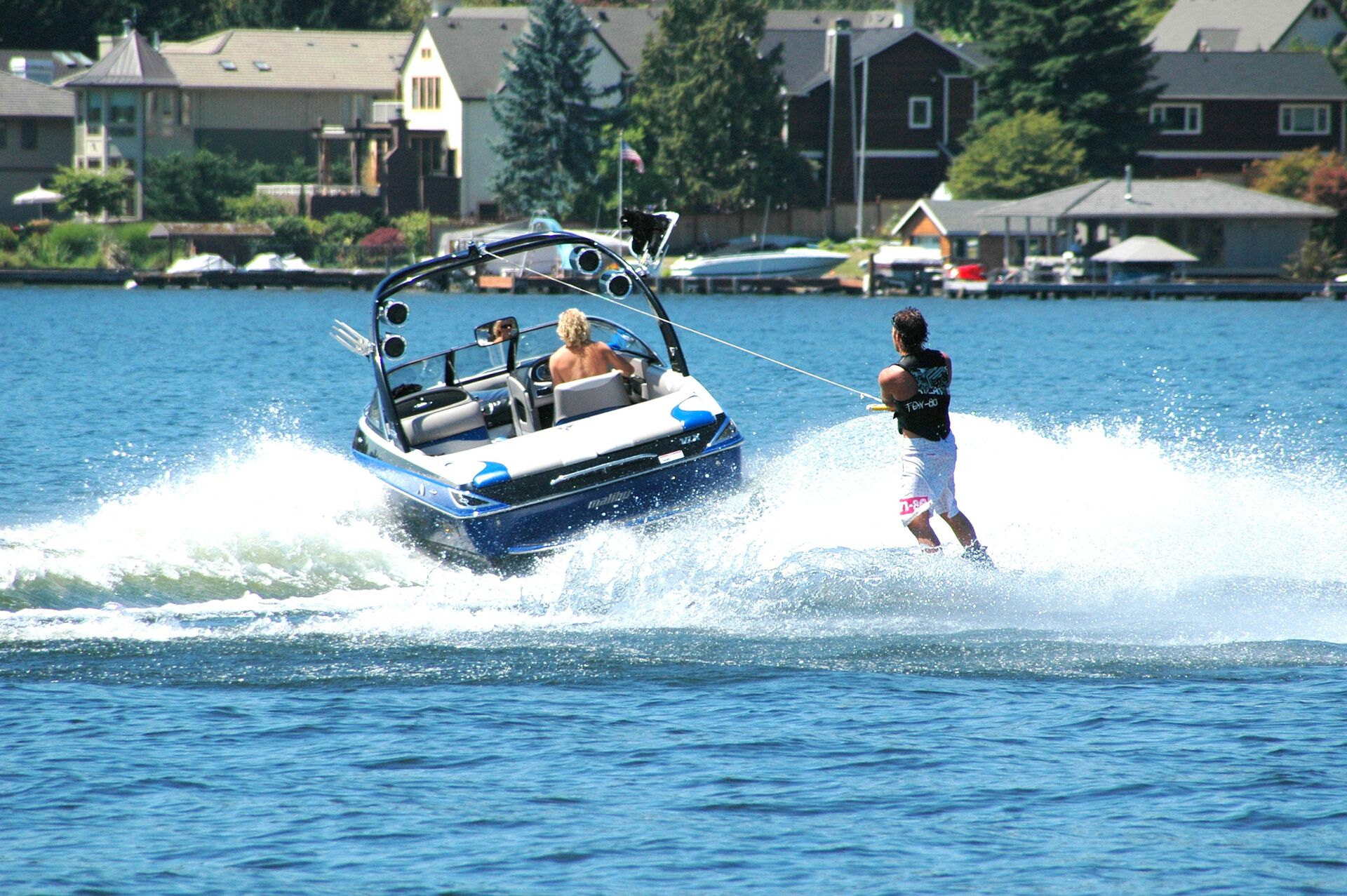 A guy waterskiing behind a boat on a lake.