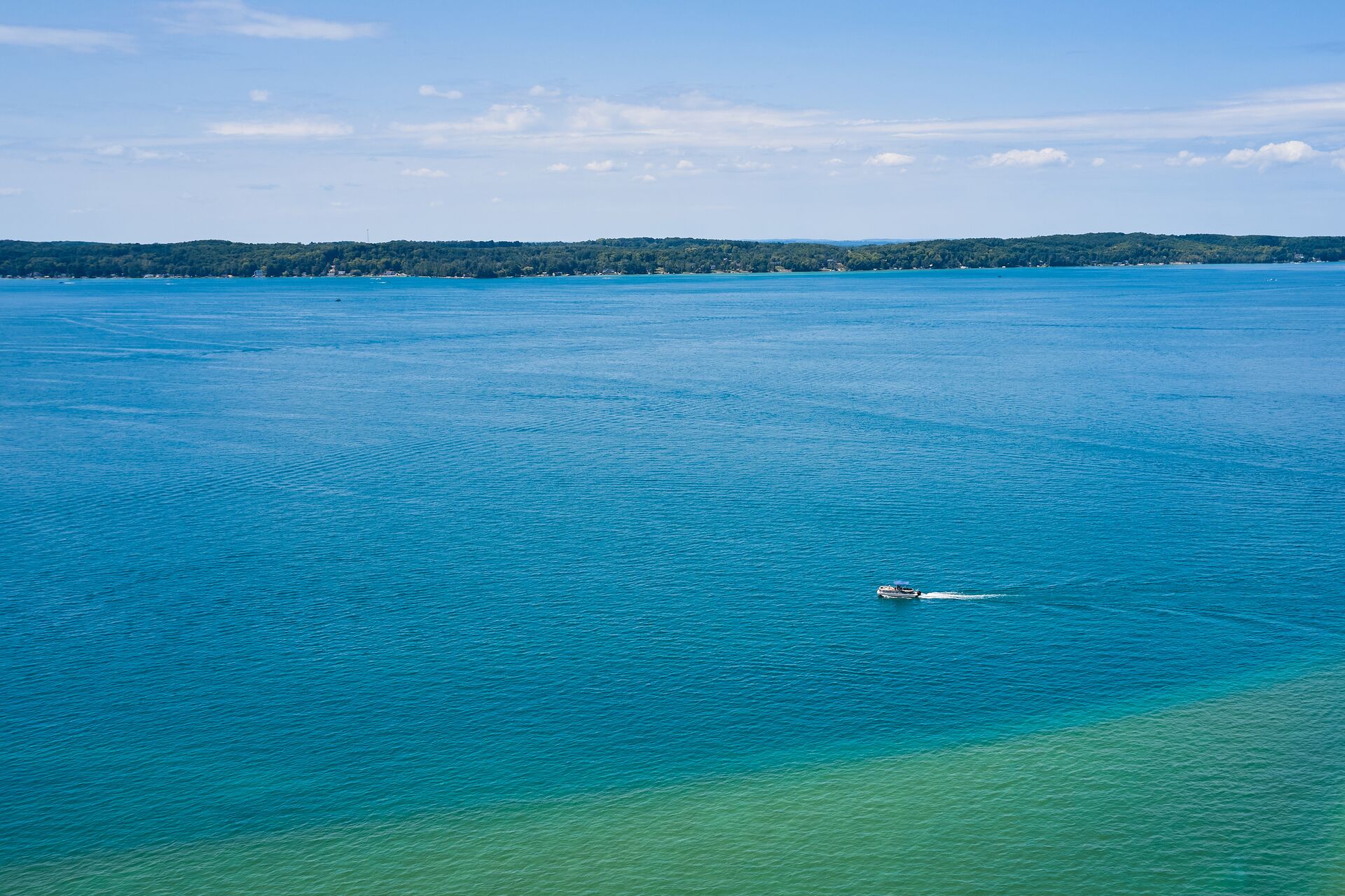 Overhead view of a boat in the distance on a lake, boating in Idaho concept.