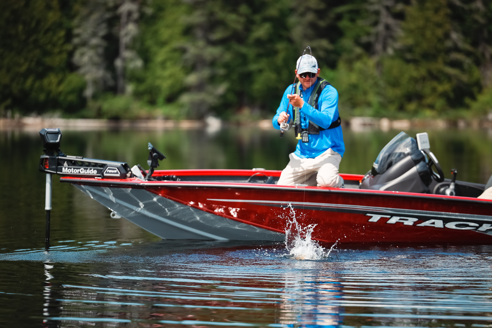 An angler on a red boat reels in a fish, fishing and boating in North Carolina concept.