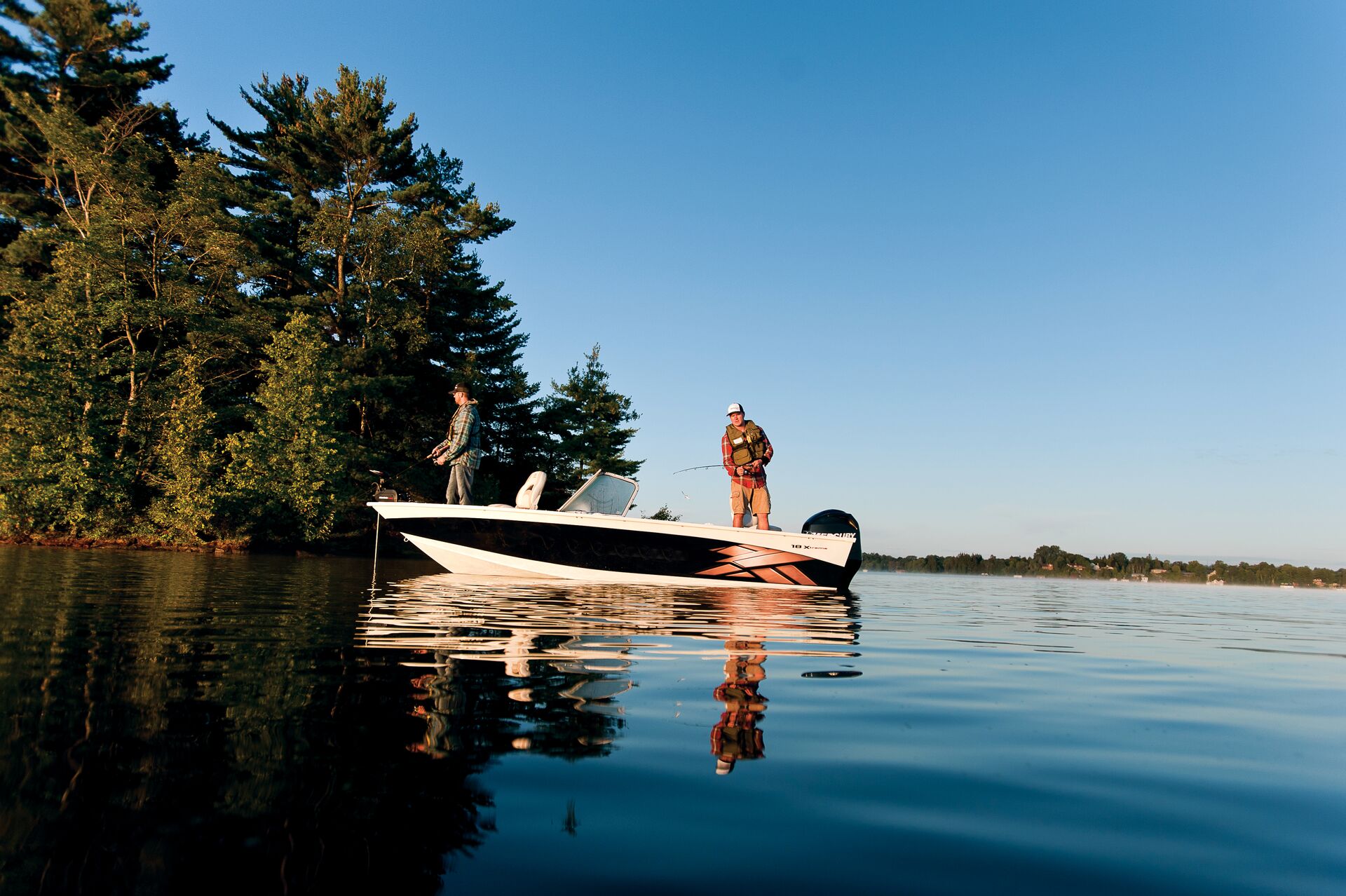 Two anglers fishing from a boat, fall fishing concept.