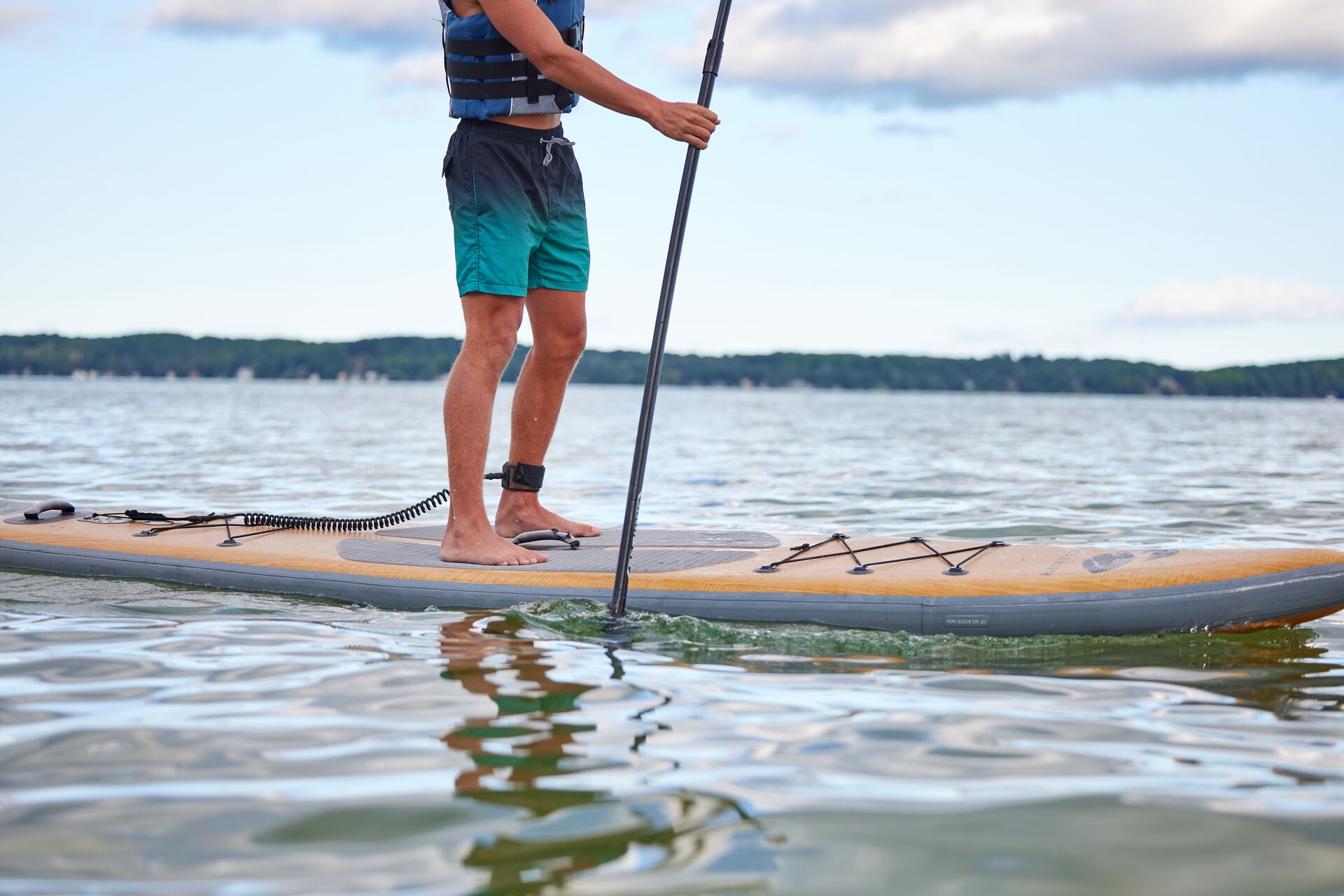 Someone standing on a paddle board on the water.