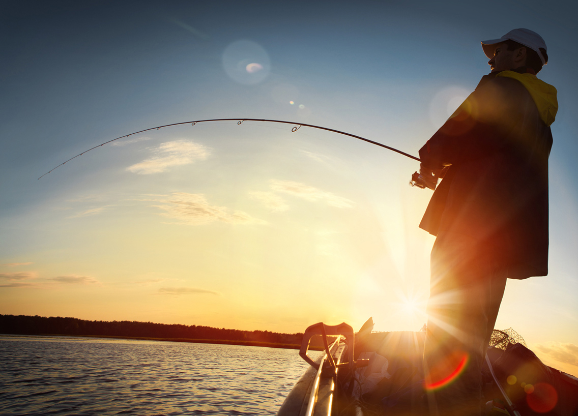 The sun behind a man on a boat with a fishing line in the water, fishing in Nunavut concept. 