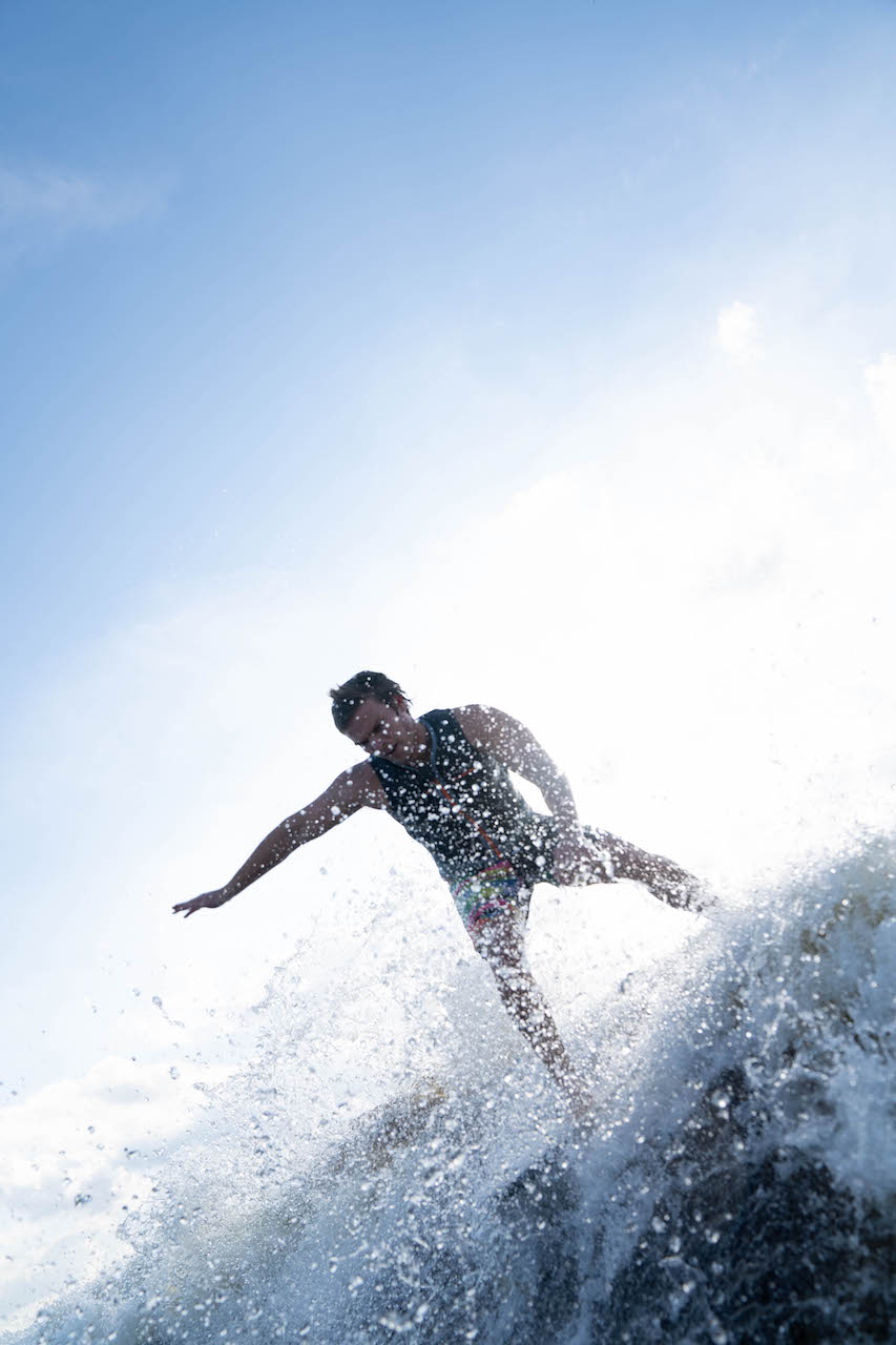 Keenan Flegel on a wake surfing board in the water.
