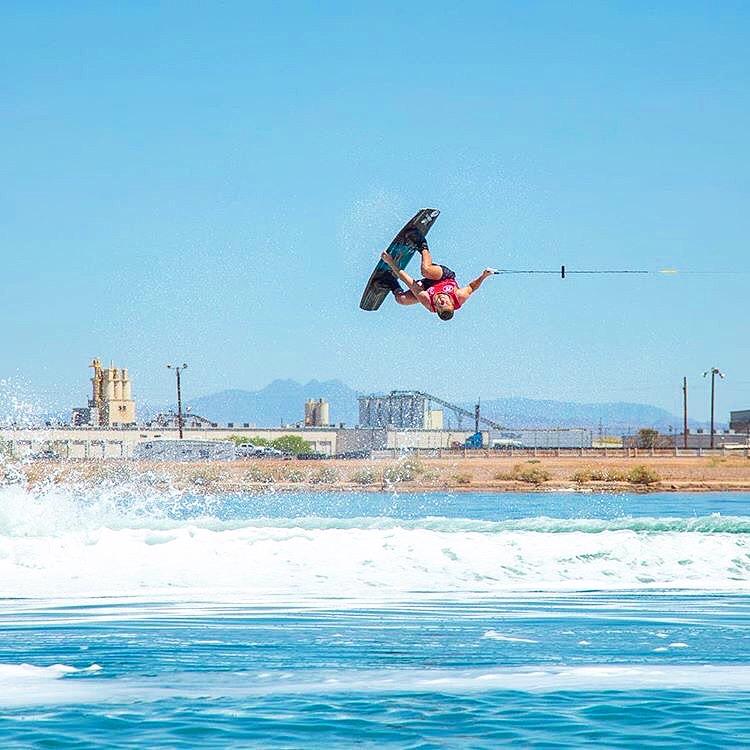 A person in the air during a wakeboarding flip. 