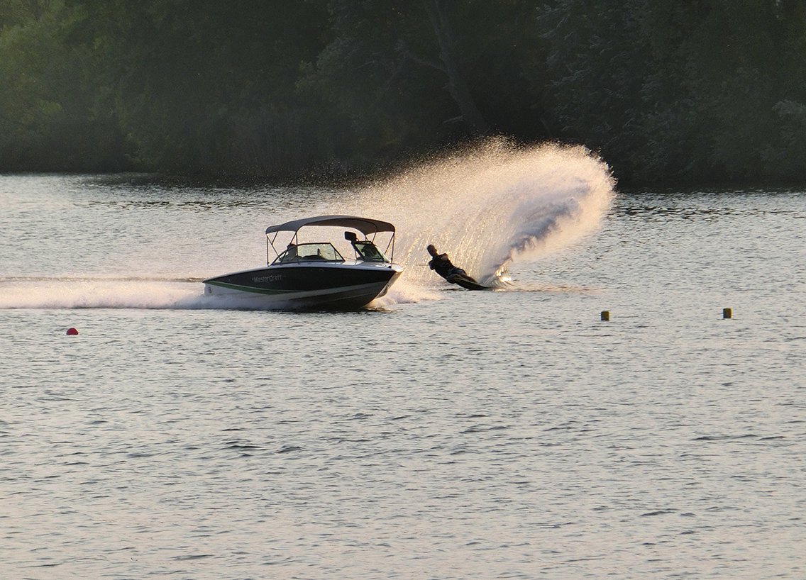 A boat pulling someone on a jet ski. 