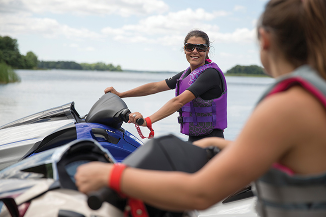 Two girls next to each other on personal watercraft (PWCs), boating in Quebec concept. 