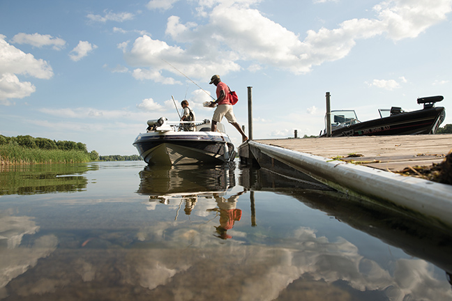 People getting on a boat by a dock.