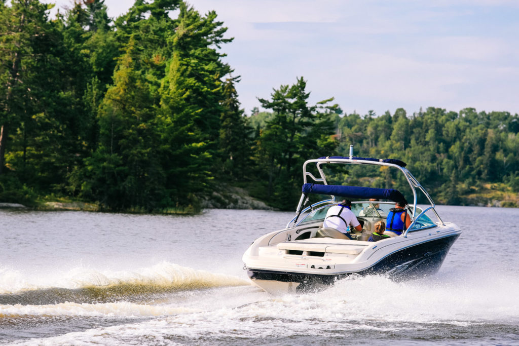 People enjoying a boat moving quickly on the water.
