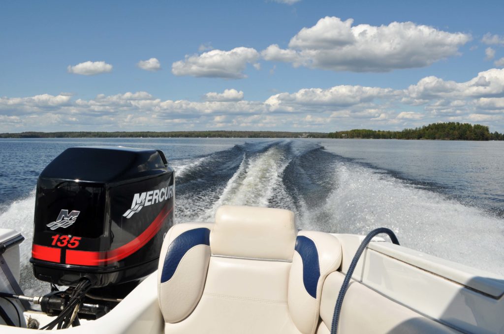 A view behind a boat moving across the water, know drinking and boating facts in Canada concept.