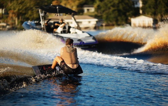 A wakeboarder catching the wake on the water. 