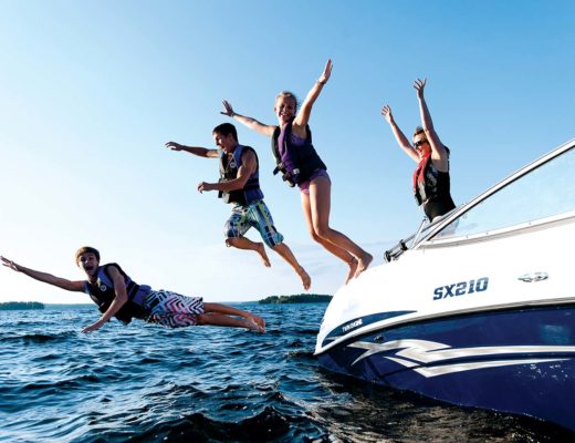 Boaters wearing lifejackets jumping into the water