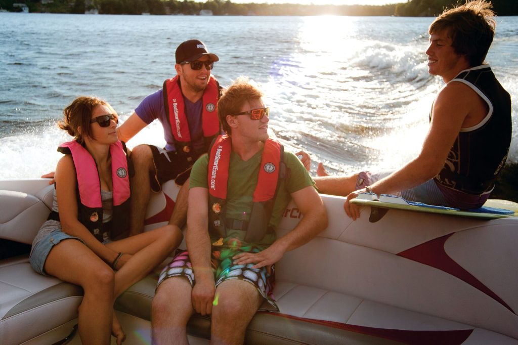 People wearing lifejackets on a boat, don't drink and drive a boat concept.