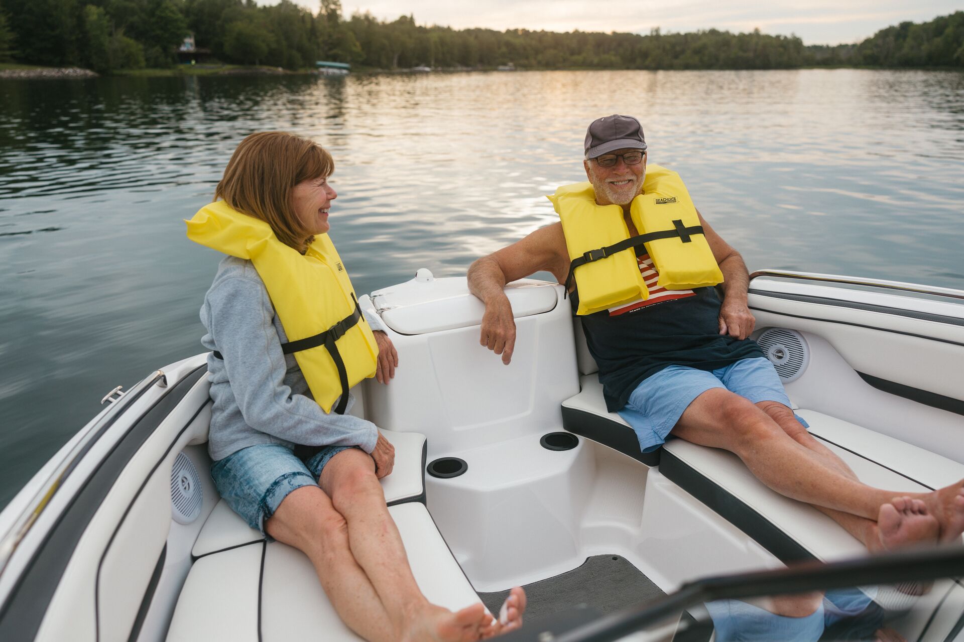 A man and woman wearing life jackets on a boat, Alabama life jacket laws concept.