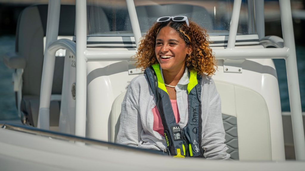 A smiling woman wearing a lifejacket on a boat, boat registration in Texas concept.