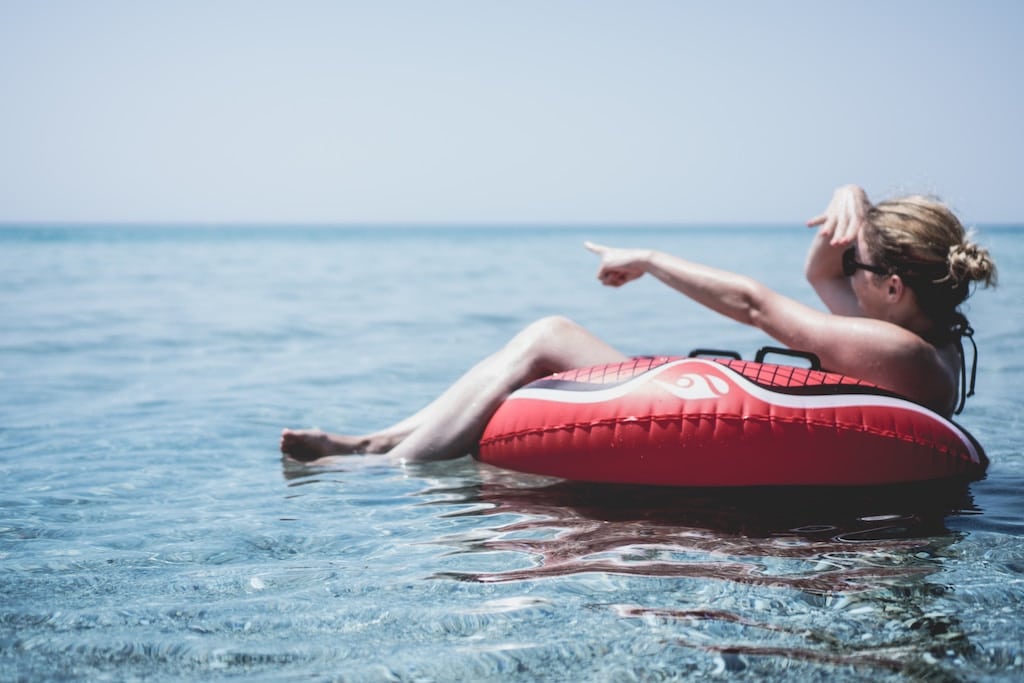 A woman floating on a tube, earning boating badges of honor concept. 