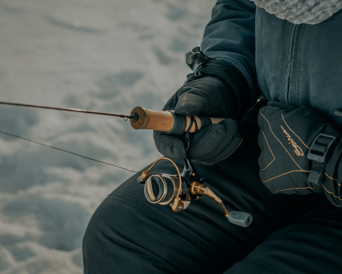 Close up of person holding an ice fishing rod