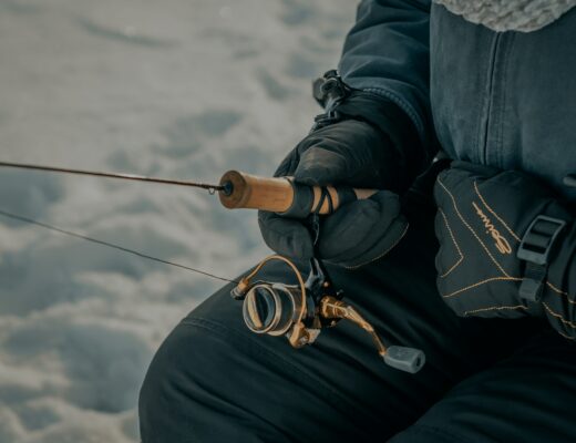 Close up of person holding an ice fishing rod