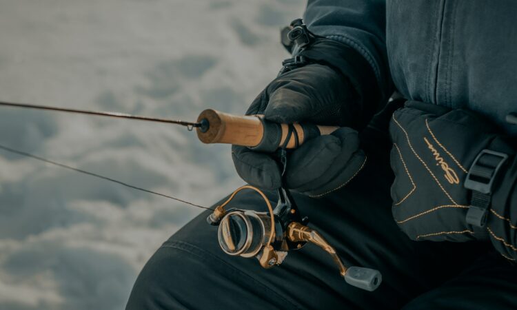 Close up of person holding an ice fishing rod