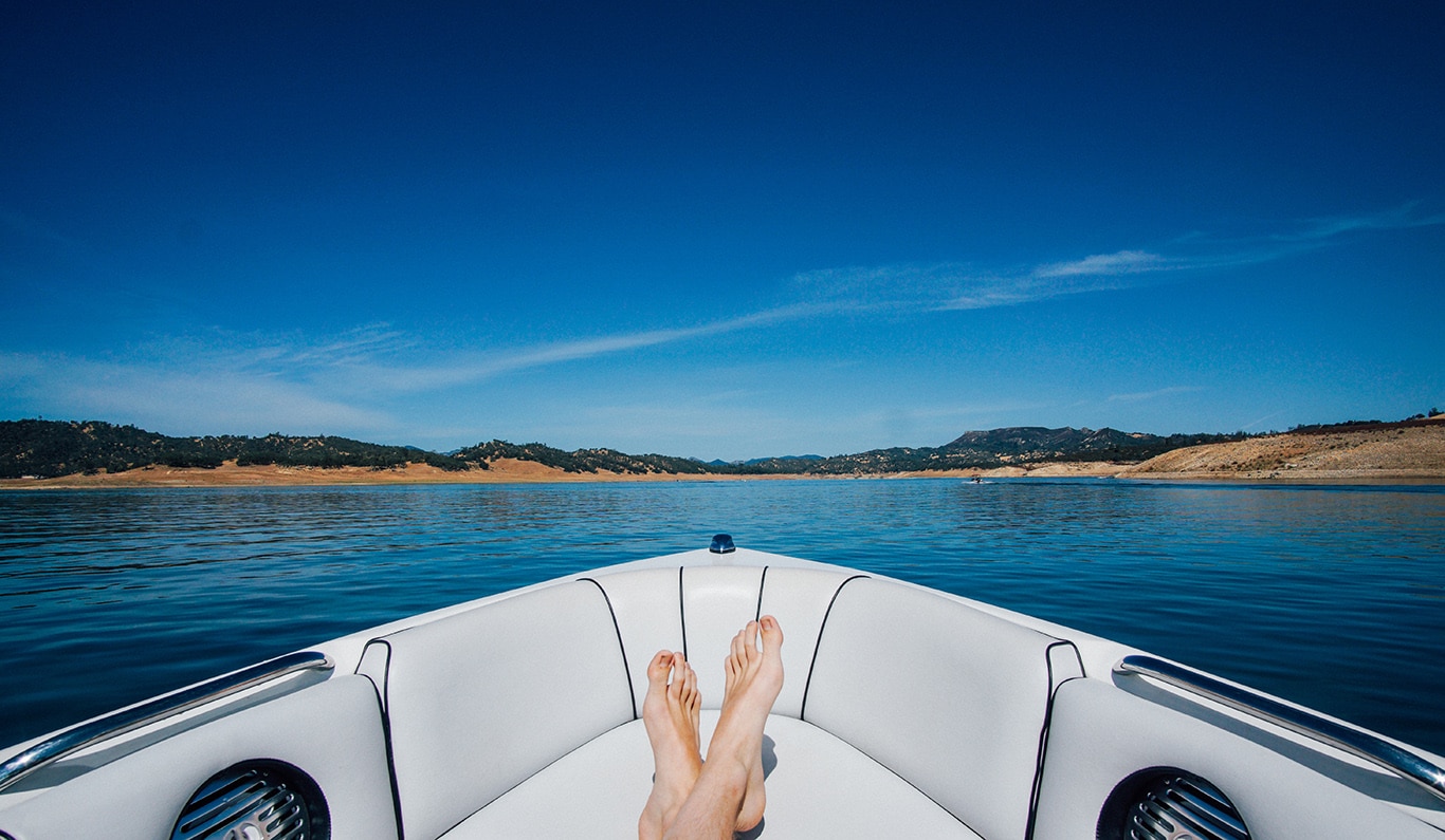 boater with feet up on the seat of a bowrider